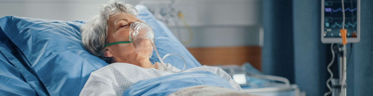 older woman, sick in hospital bed with an oxygen mask