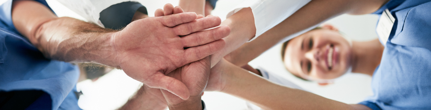 Group of people all putting their hands in the middle